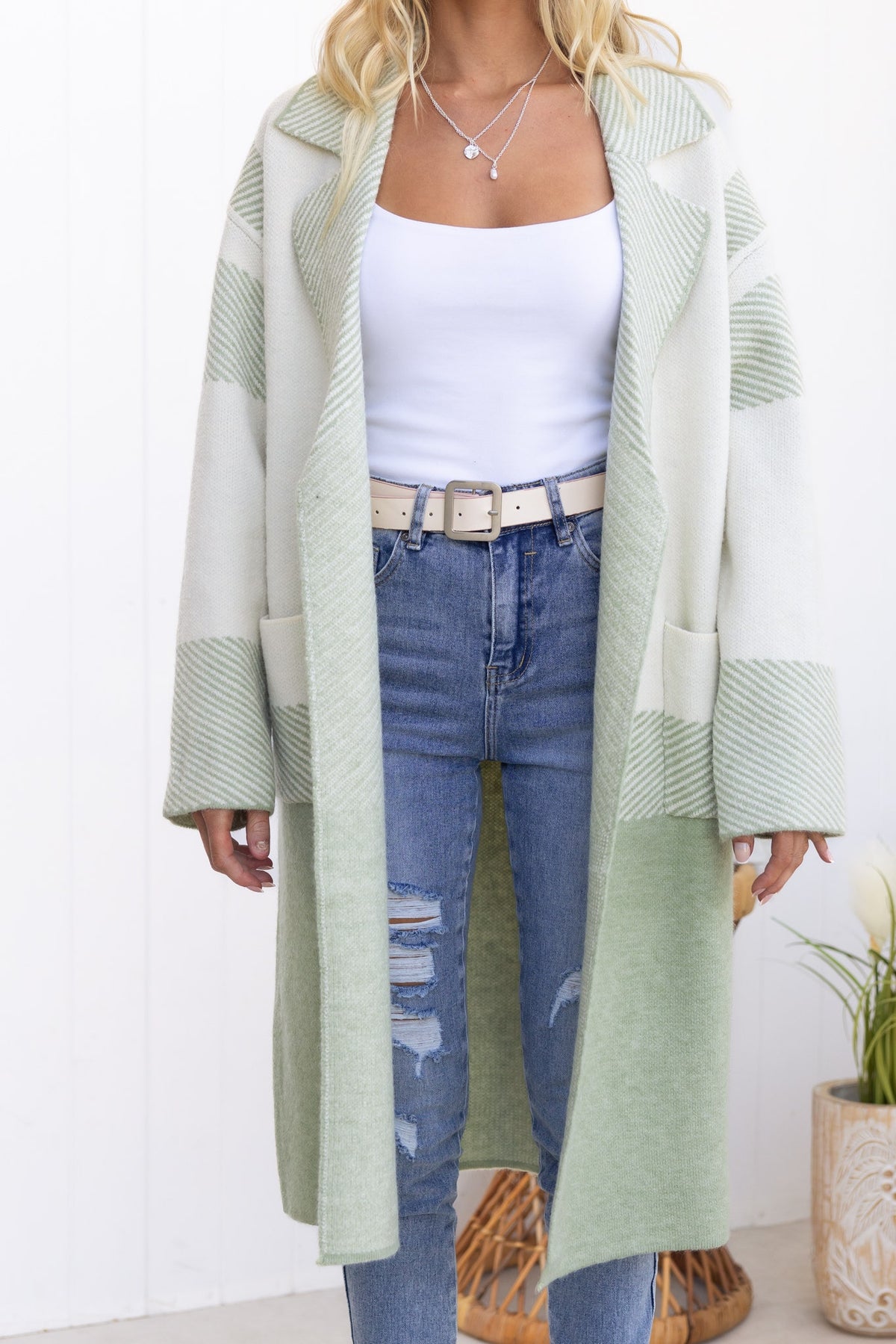 Kellan Cardigan in light green with pockets, longline fit, worn over a simple white tank and distressed jeans.