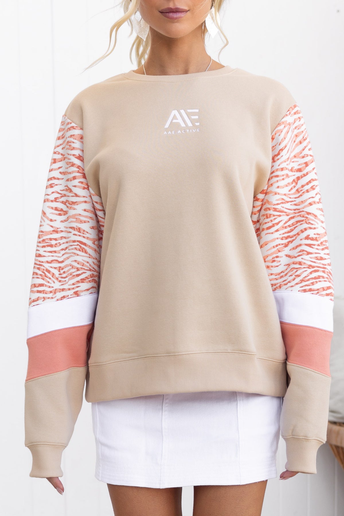 Elana Jumper featuring round neckline, panelled sleeves, and fleece lining in beige with vibrant print accents.
