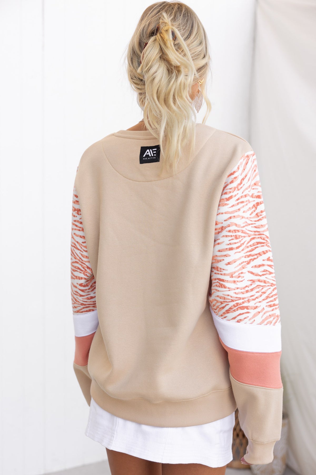 Back view of Elana Jumper with panelled sleeves in beige and tiger stripes, featuring a fleece lining for comfort.