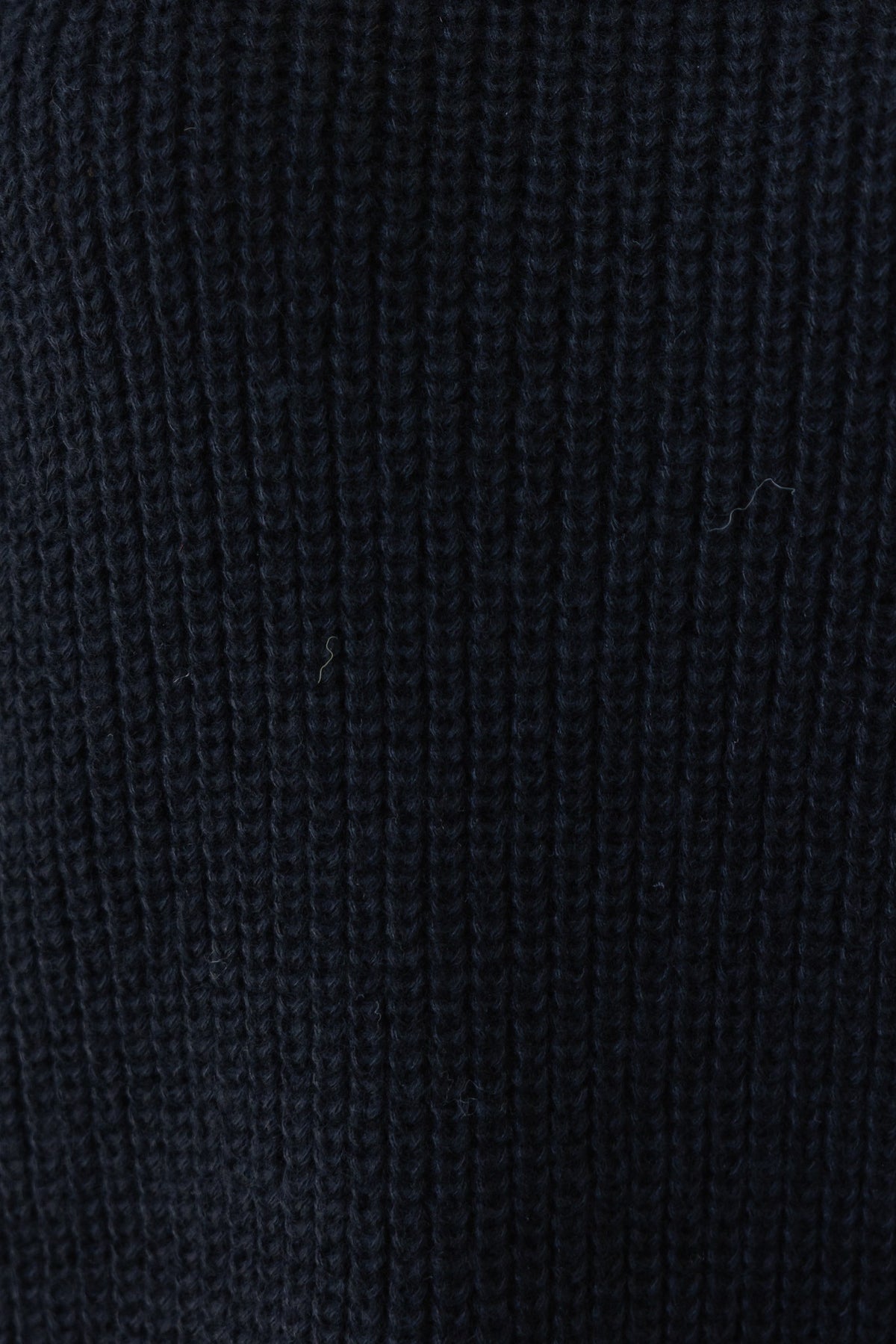 Close-up of textured black knit fabric showcasing stretch and softness, ideal for stylish casual wear.