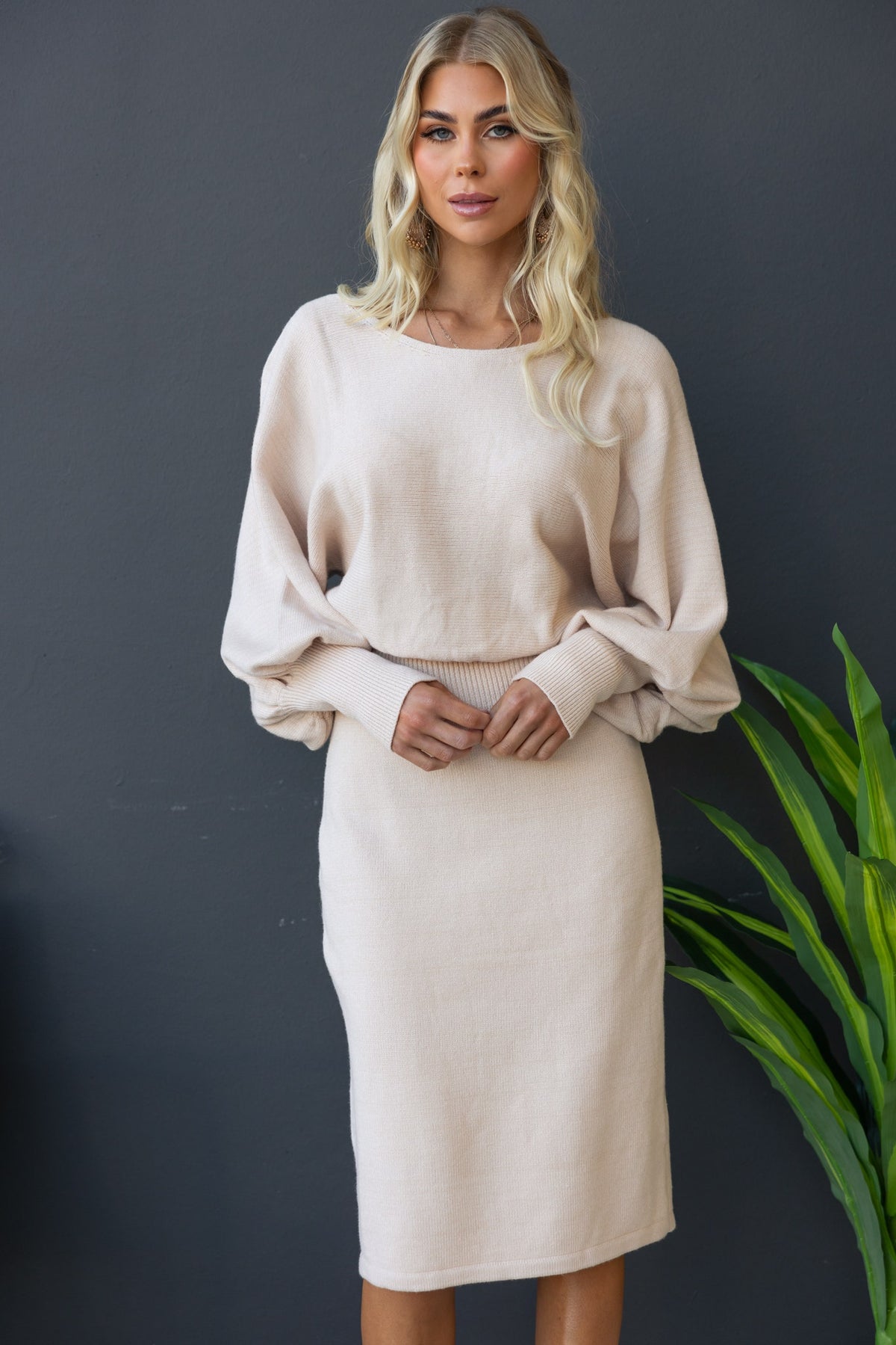Model wearing a beige Jadala Midi Dress with boat neckline and ribbed knit material, styled for a relaxed fit.