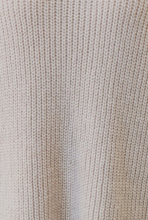 Close-up of Whinnie Dress knit material, featuring soft textured fabric in a neutral color.