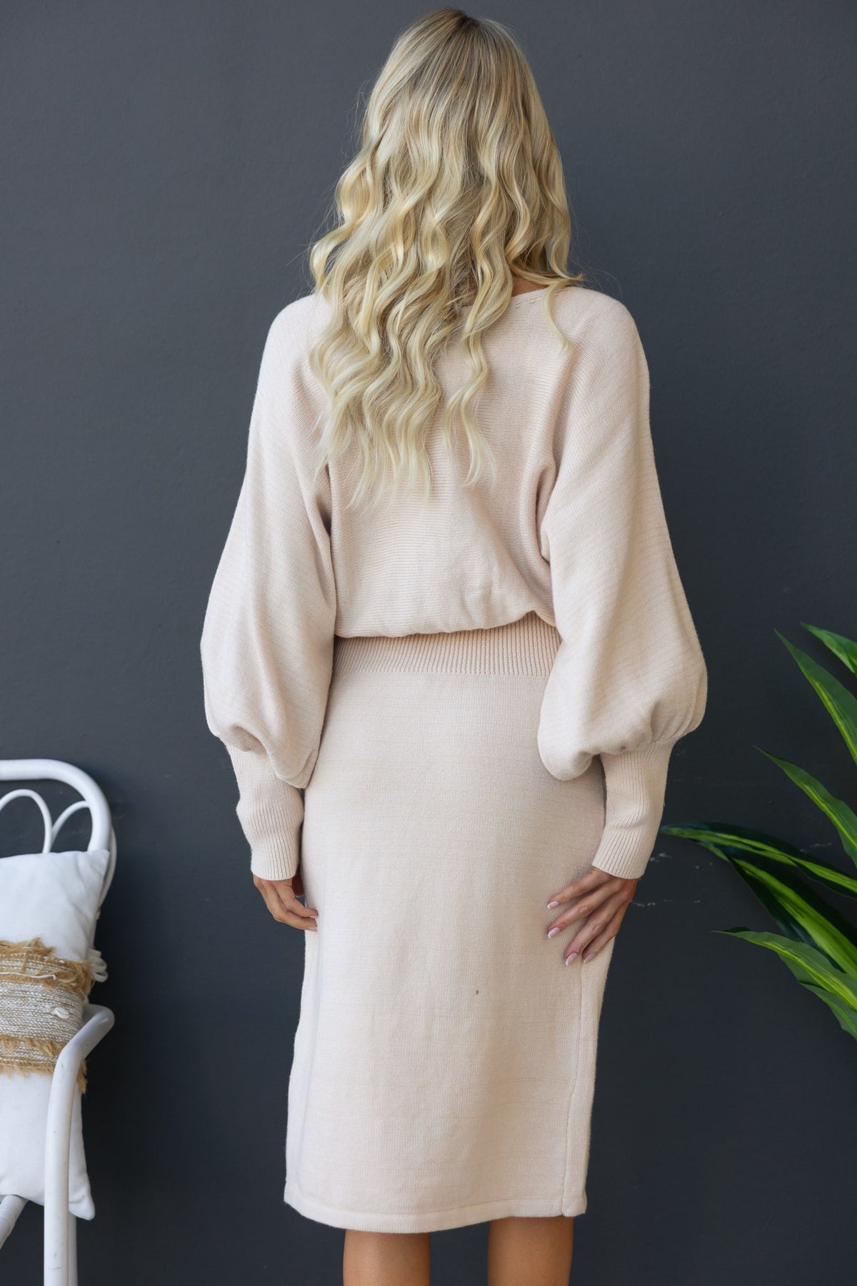 Back view of the Jadala Midi Dress featuring balloon sleeves and a fitted style in soft beige color.