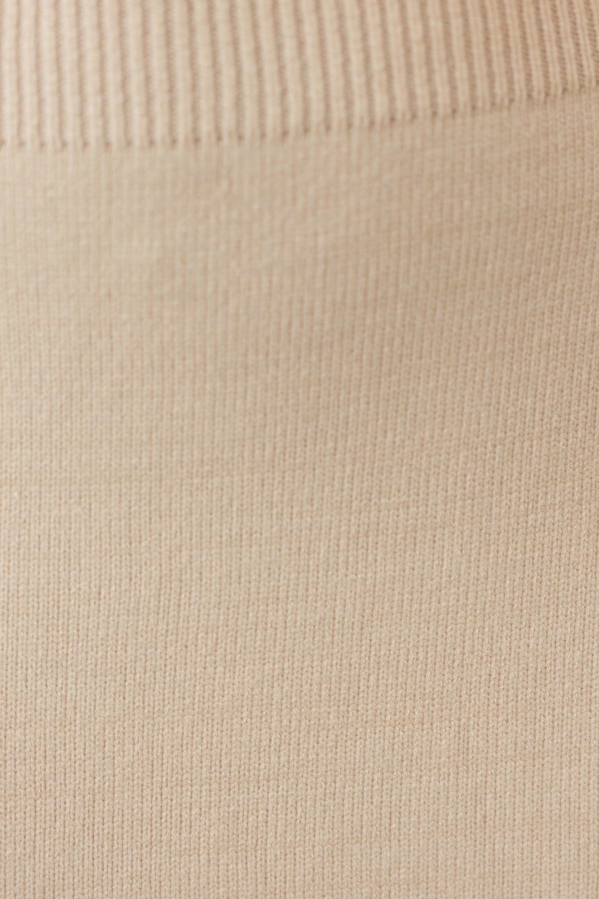 Close-up of the ribbed knit fabric showcasing soft beige texture of the Jadala Midi Dress.