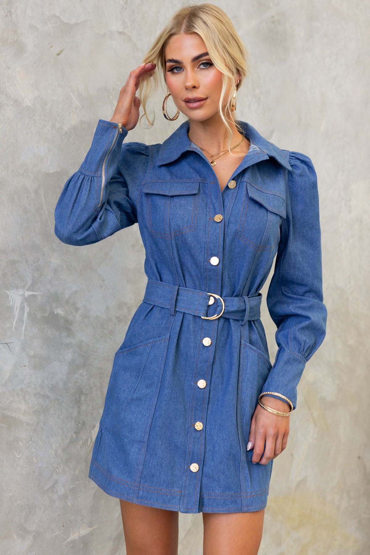 Stylish model wearing a Childers denim dress with button-up front, faux pockets, and removable belt.