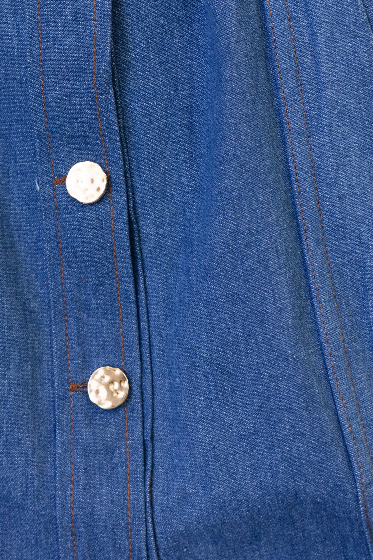 Close-up of Childers Denim Dress showing button details and blue denim fabric.