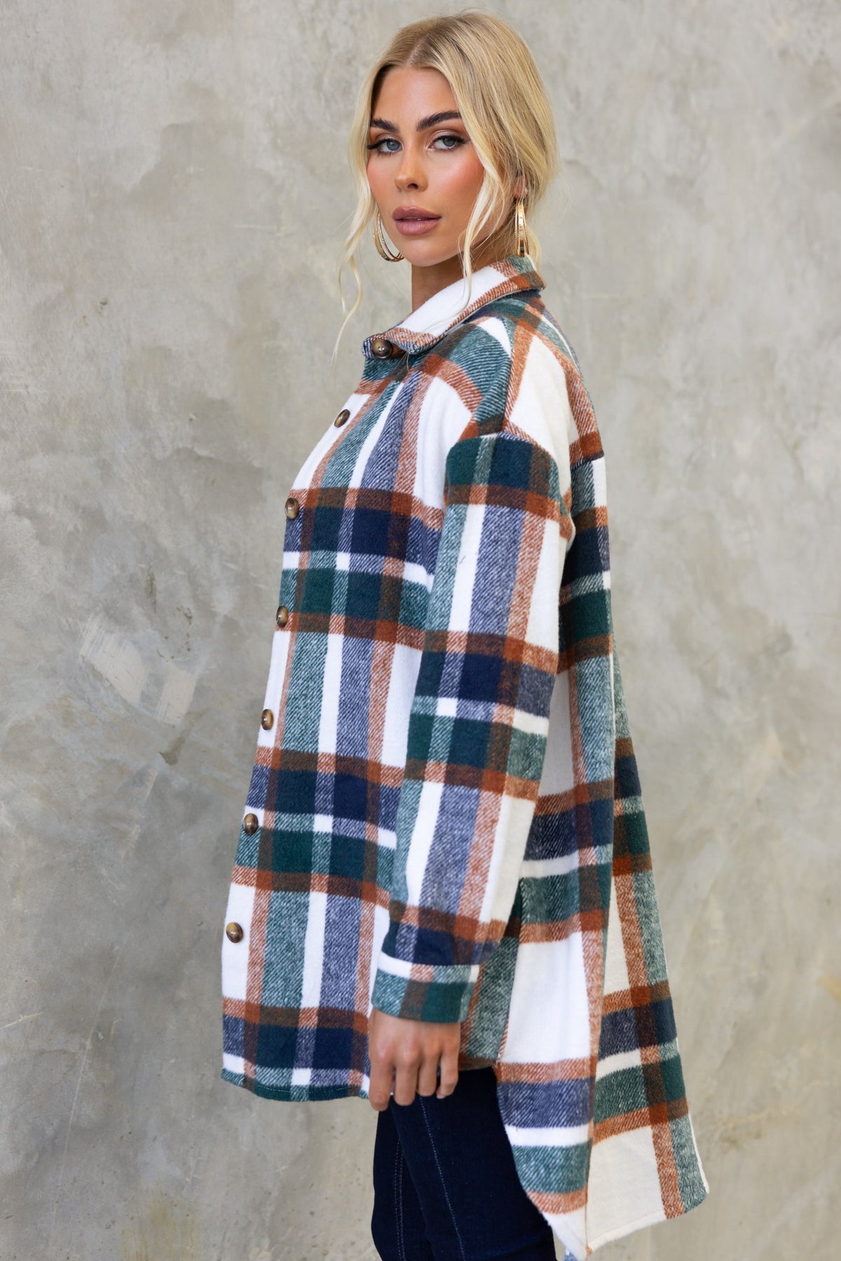 Model wearing the Braedyn Shacket, a high-low hem button-up with a green and orange plaid pattern.