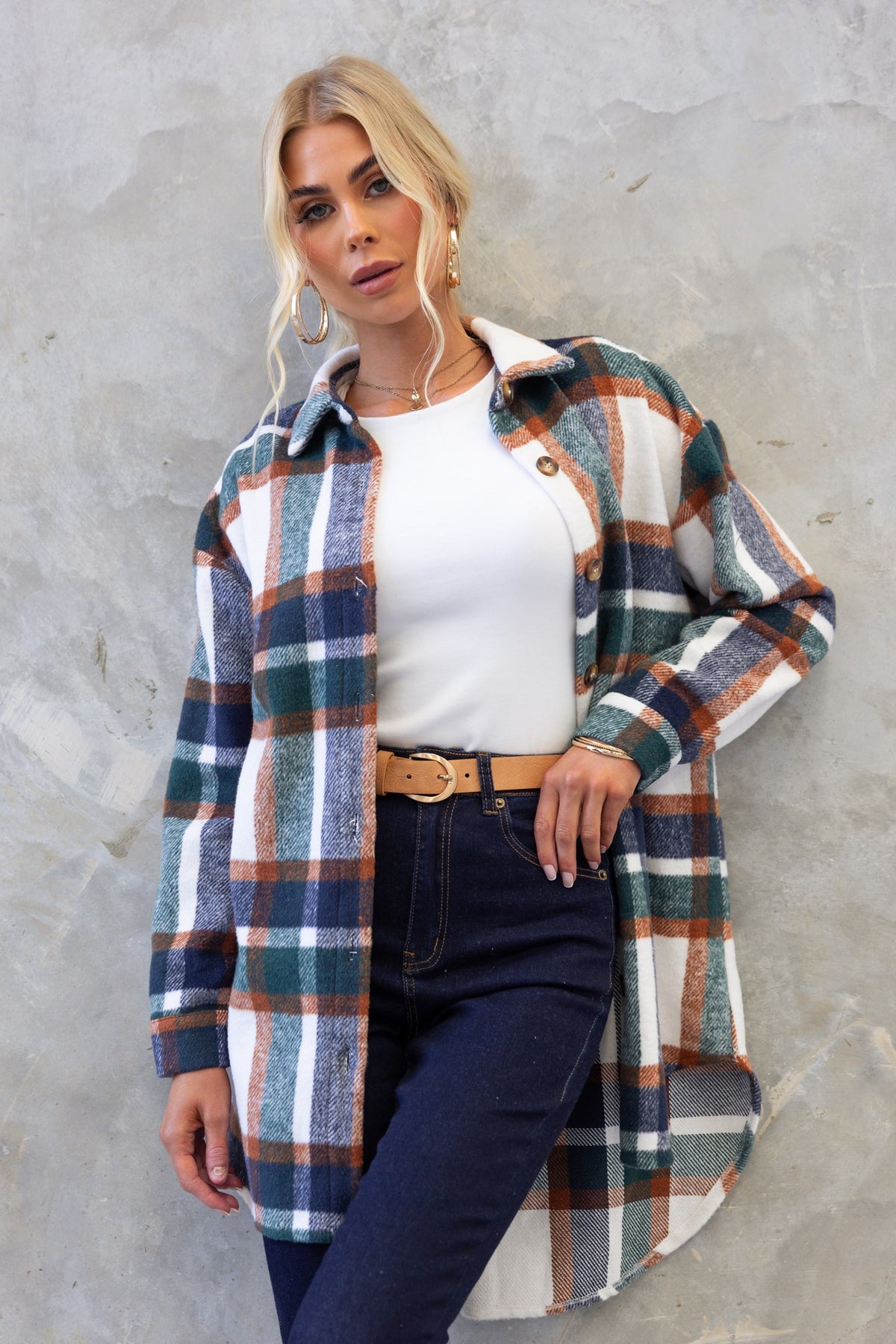 Model wearing a plaid Braedyn shacket with a high-low hem, styled with a white tee and dark jeans.