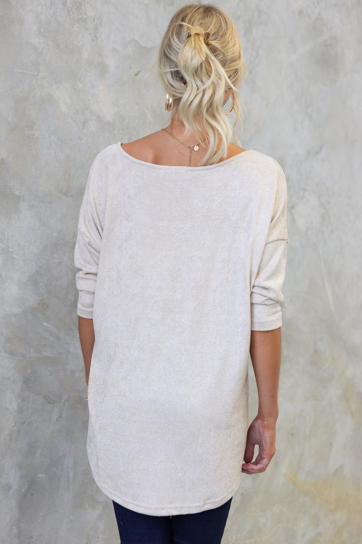 Back view of a woman wearing the Vargo Top with boat neckline and high-low hem, showcasing a soft, stretchy fabric.