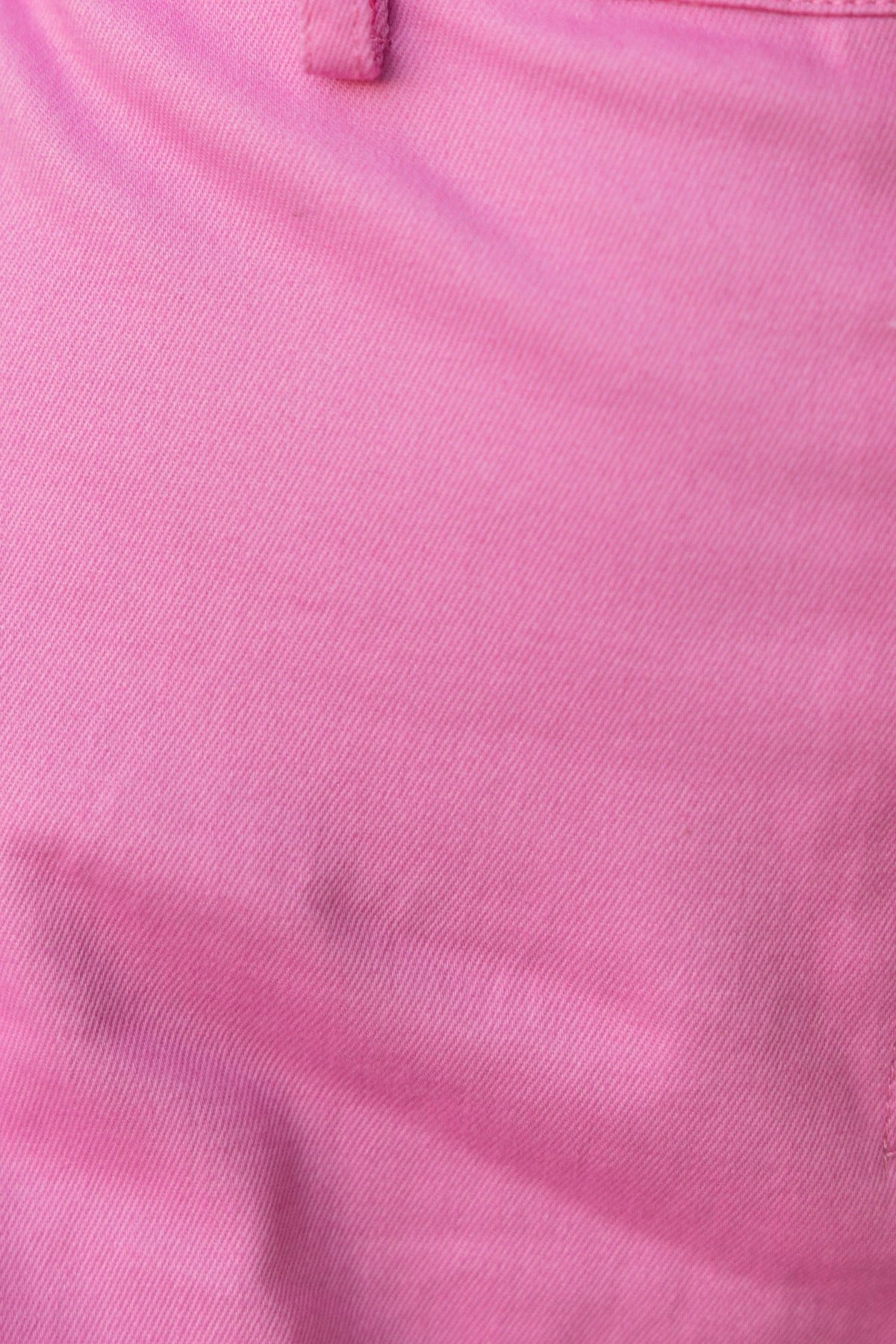 Close-up of pink denim fabric showing texture and detail, perfect for stylish clothing designs.