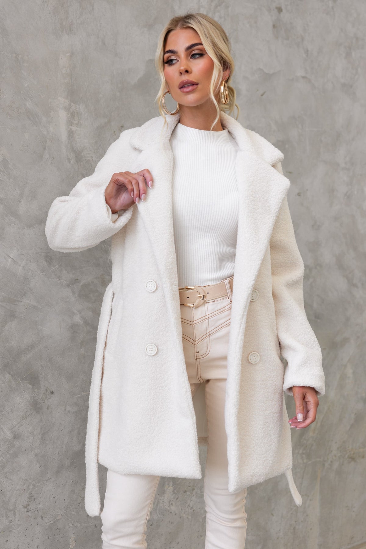 Stylish white teddy coat featuring a lapel, buttons, and removable tie, perfect for a trendy winter look.