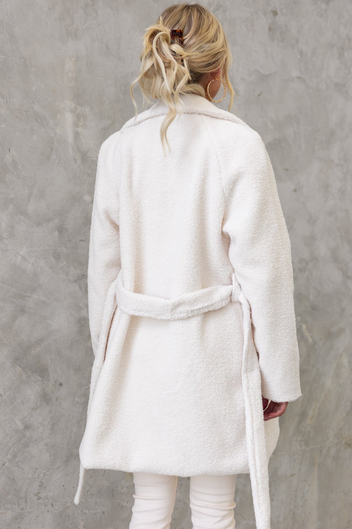 Back view of a model wearing a cozy white teddy coat with removable tie and relaxed fit.