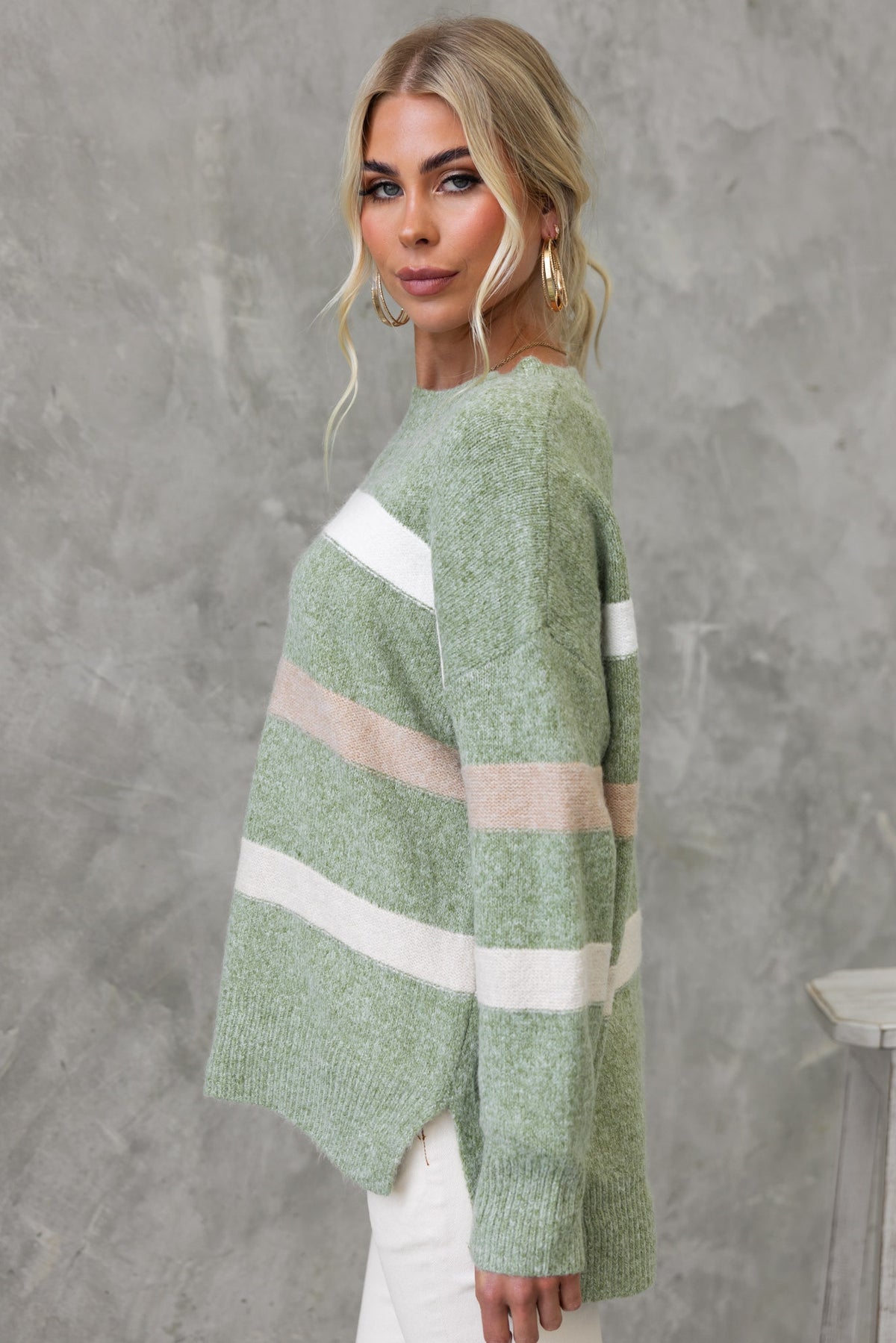 Model wearing a green striped Lukki Jumper with round neckline and high-low hem, styled casually.