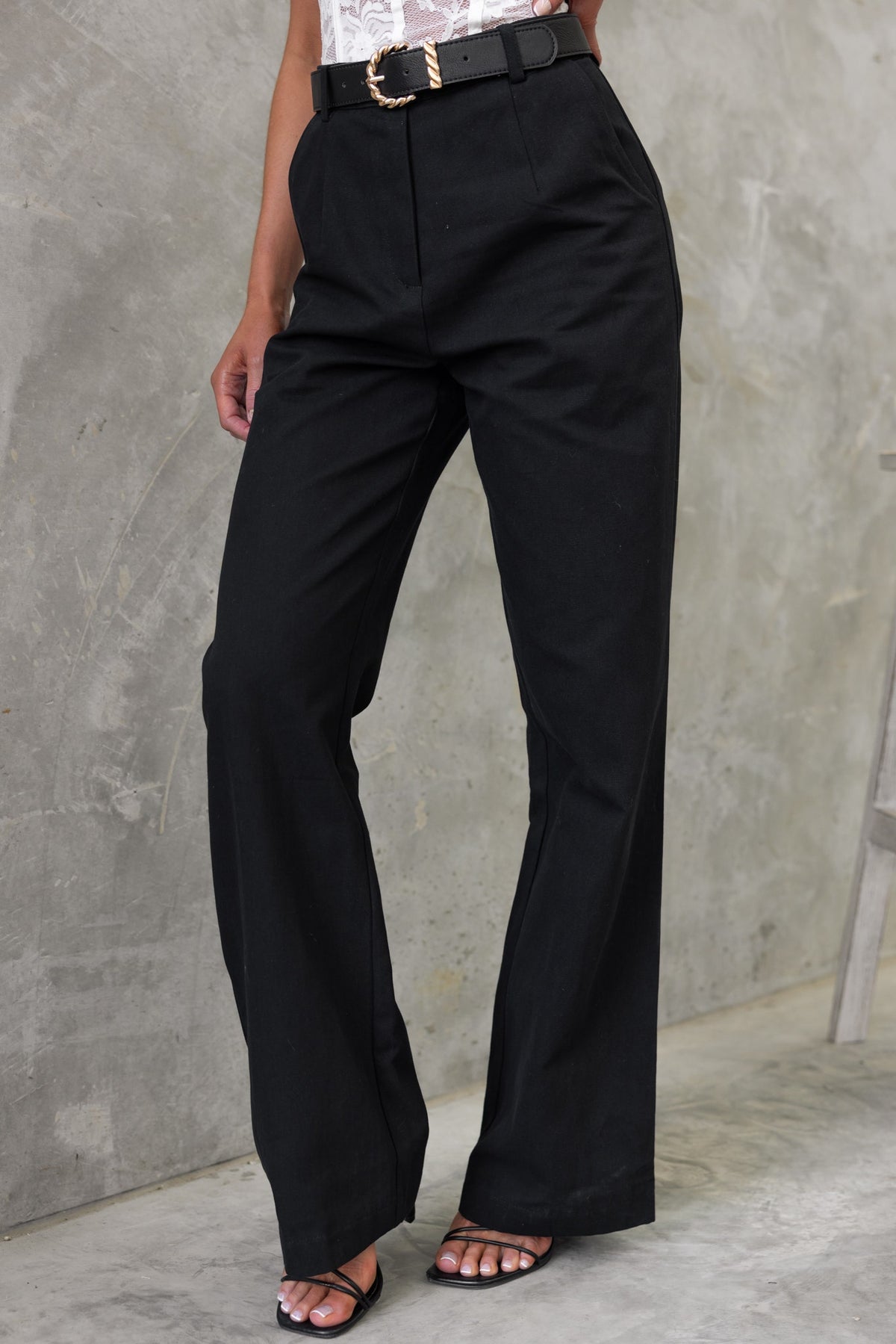 Rayden black denim pants with mid-high waist, wide legs, and front pockets showcased on model.