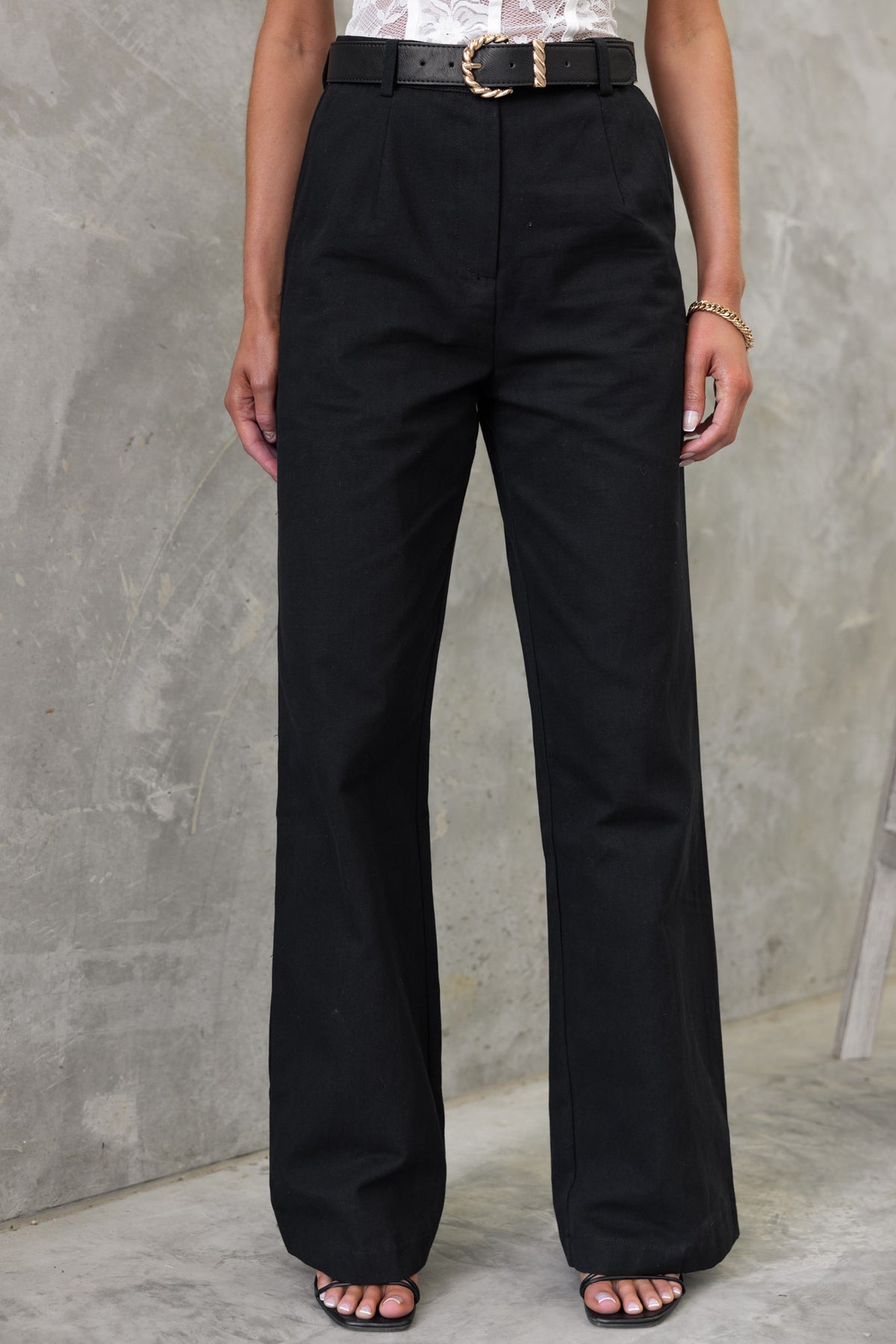 Rayden Black Denim Pants featuring wide legs and mid-high waist, styled with a belt and minimalistic accessories.