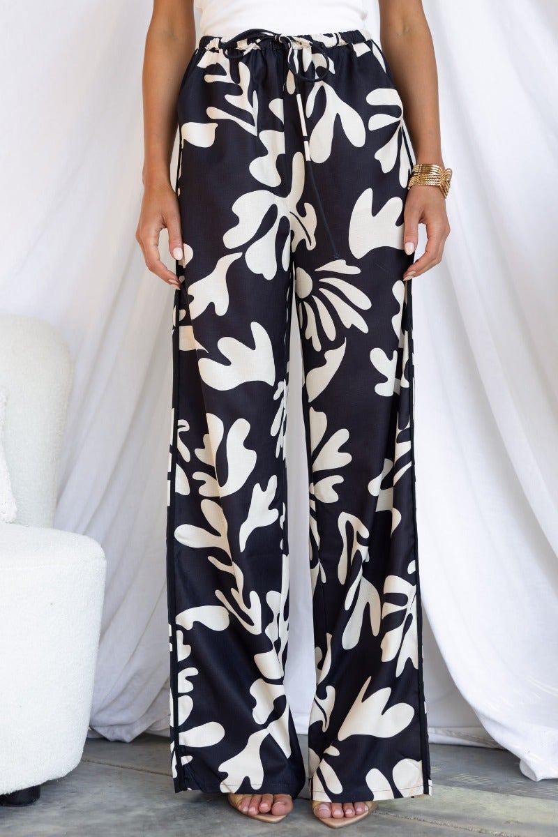Stylish White Lies Pants featuring a black-based print, elastic waistband, and wide-leg fit.