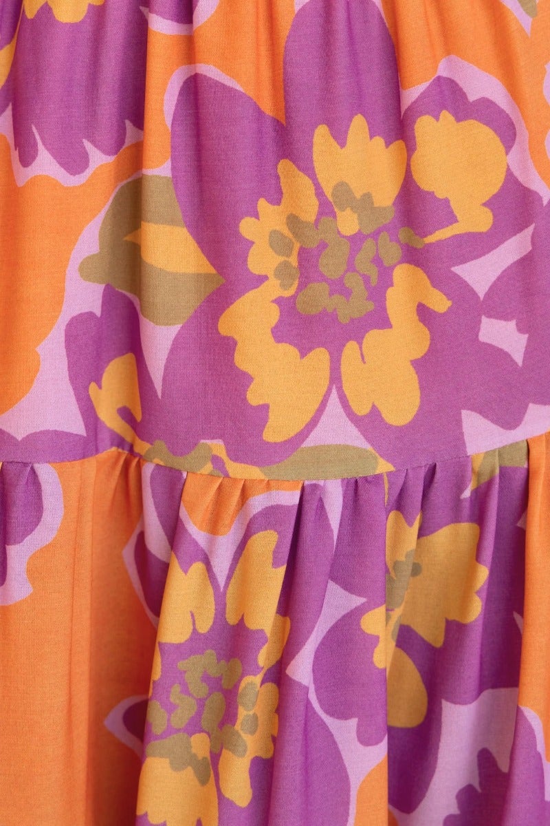 Close-up of vibrant floral print featuring orange, purple, and yellow colors on fabric for Over Joyed Maxi Dress.