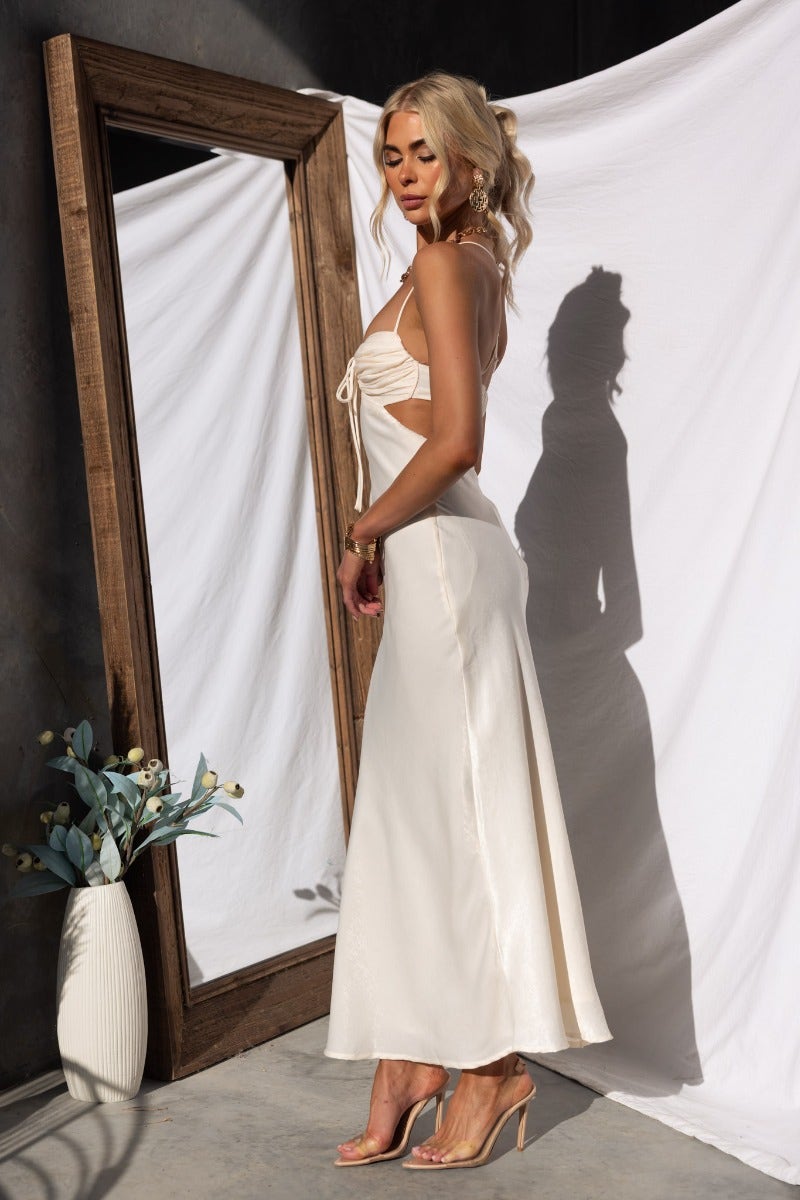 Bayside Maxi Dress featuring adjustable straps and cut-out waist, styled with a chic mirror reflection.