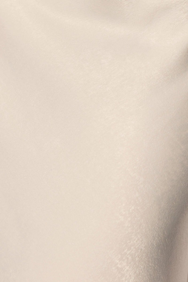 Close-up of beige fabric texture from the Bayside Maxi Dress, showcasing its smooth and luxurious finish.