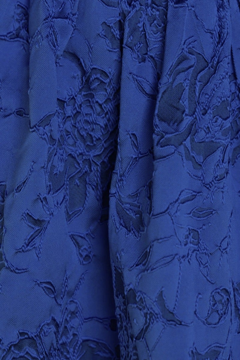 Close-up of embossed blue fabric featuring floral designs, ideal for the Stole My Heart Dress, showcasing its elegant texture.