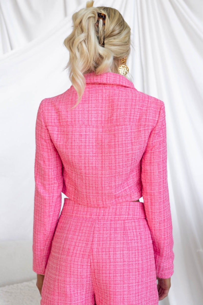 Back view of a model wearing a pink tweed Sophia Coat with collar and faux pockets, styled with elegant accessories.
