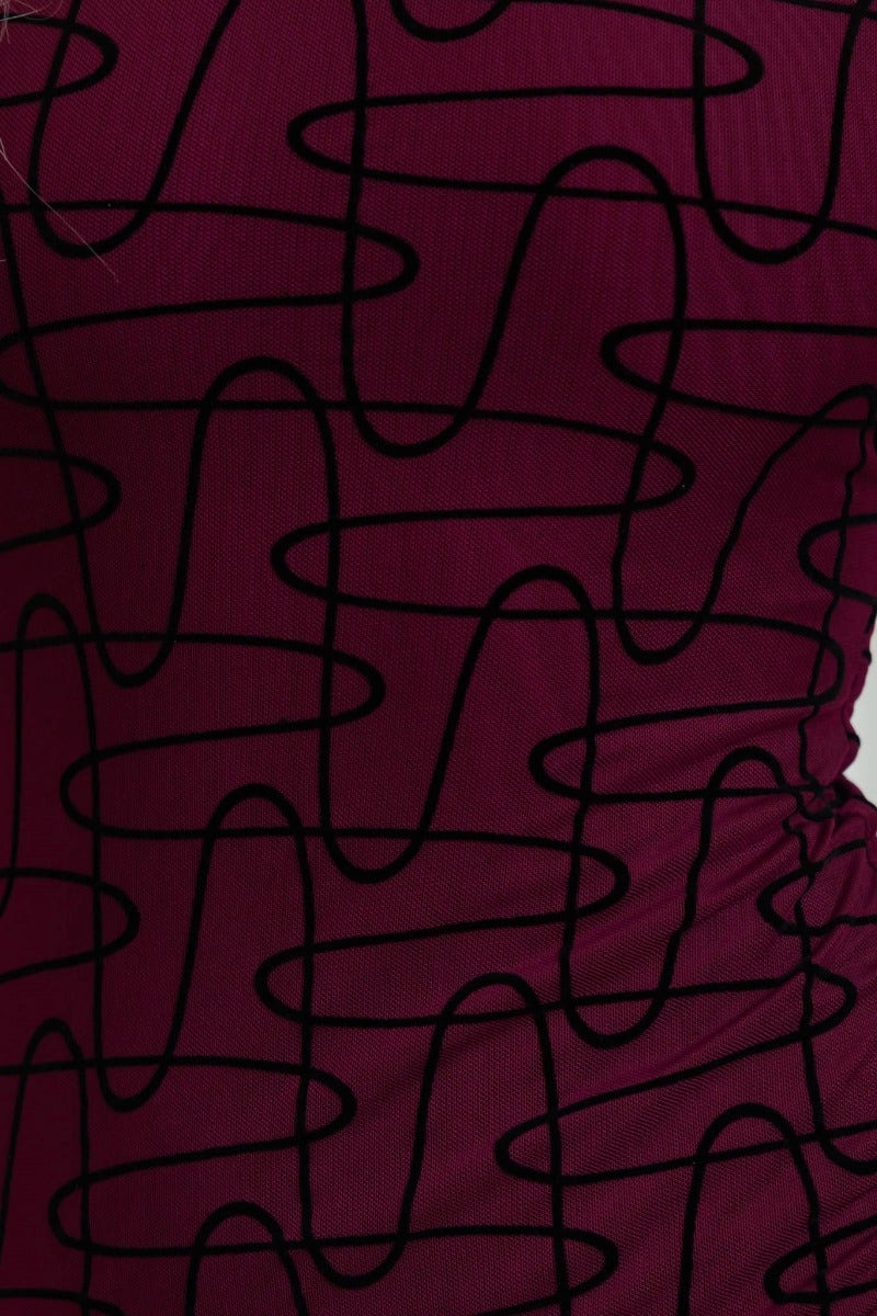 Close-up of Corinda Maxi Dress showing embossed black print on burgundy mesh fabric with a velvet feel.