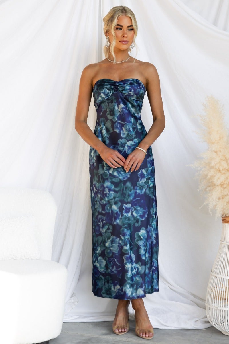 Navy floral print maxi dress worn by model, featuring a strapless design and elegant silhouette.