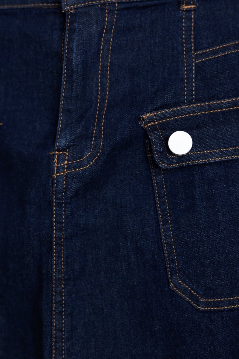 Close-up of Lewis Denim Skirt showing dark denim fabric and front pocket with silver button detail.