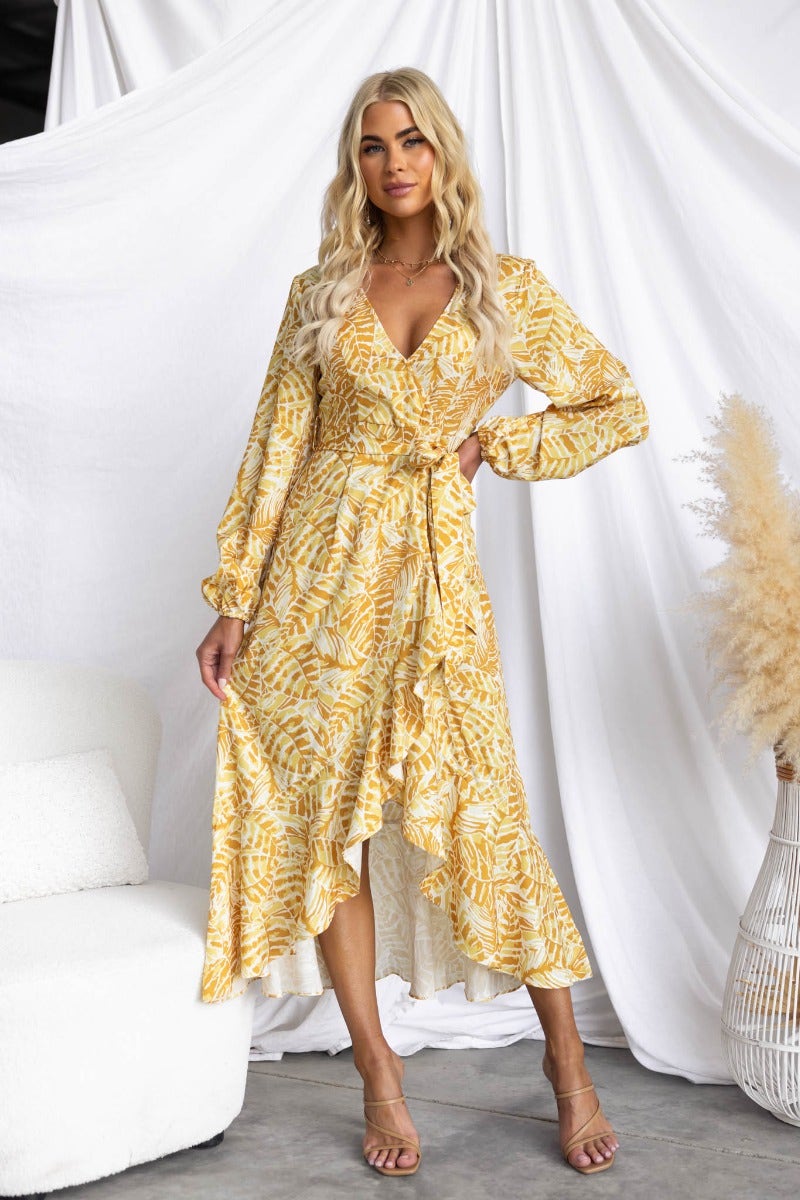 Model wearing a Kemble Midi Dress, featuring a yellow multi-colour print, V-neckline, and removable belt.