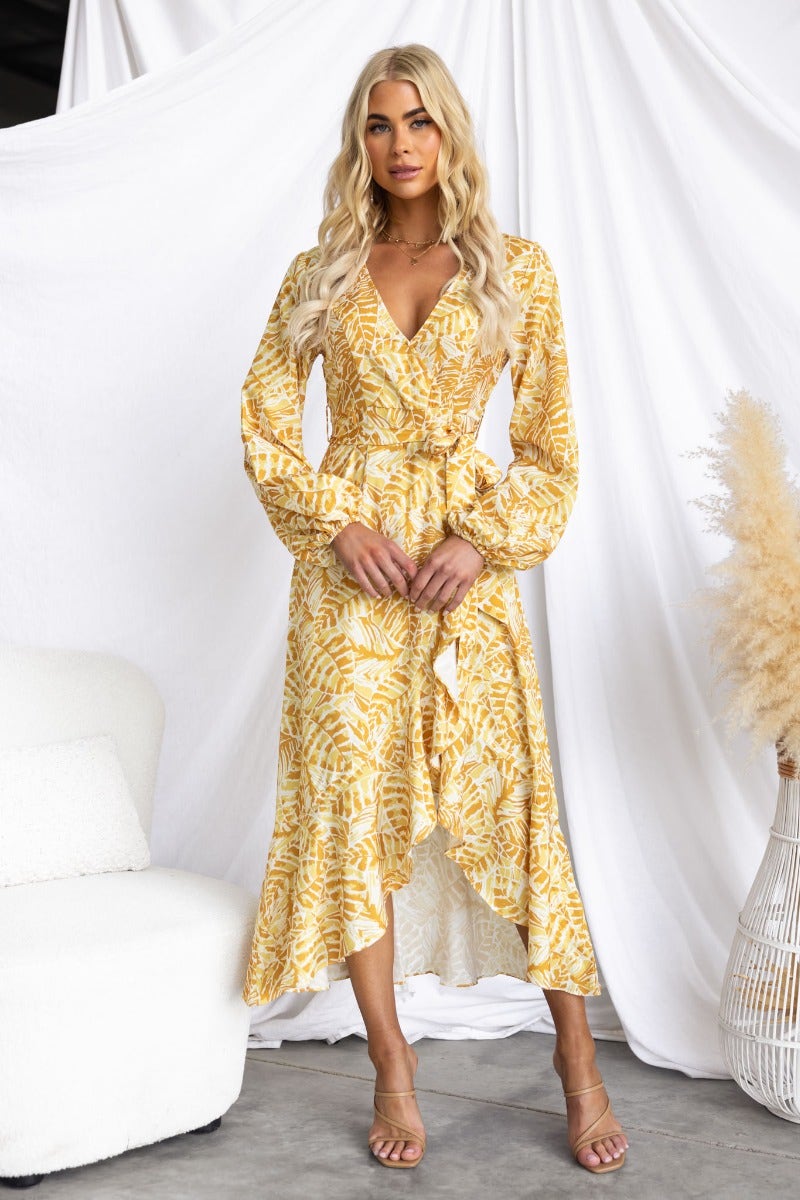 Multi-colour print Kemble Midi Dress with V-neckline, elastic cuffs, and removable belt, styled by model in a chic setting.