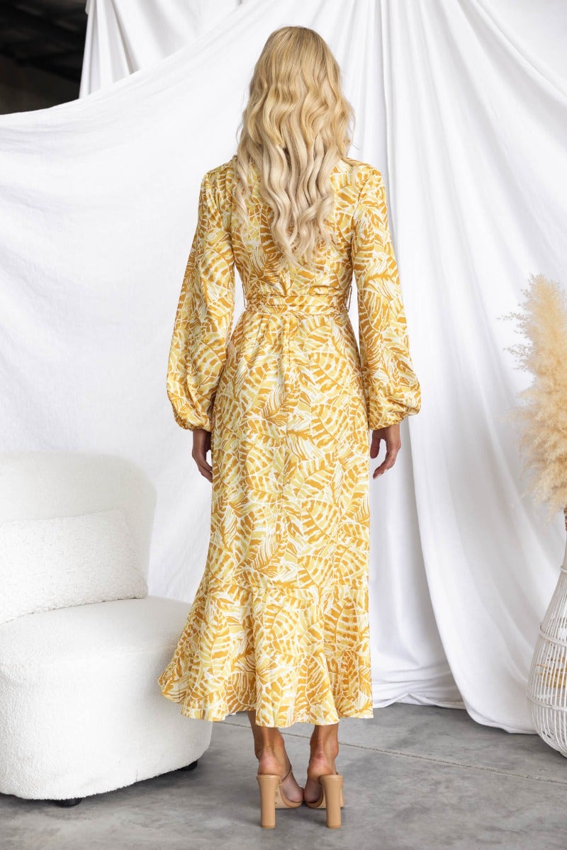 Back view of Kemble Midi Dress, a yellow multi-print dress with elastic cuffs and flowing skirt.