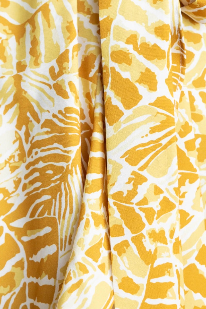 Close-up of the Kemble Midi Dress, showcasing vibrant yellow and white multi-colour print fabric with leaf patterns.