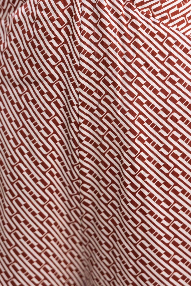 Close-up of a red and white patterned fabric featuring a chain link design, highlighting texture and detail.