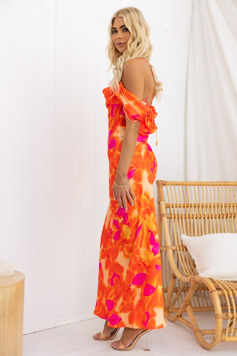 Model wearing a vibrant multi-colour Jiah maxi dress with adjustable tie straps and floral design.