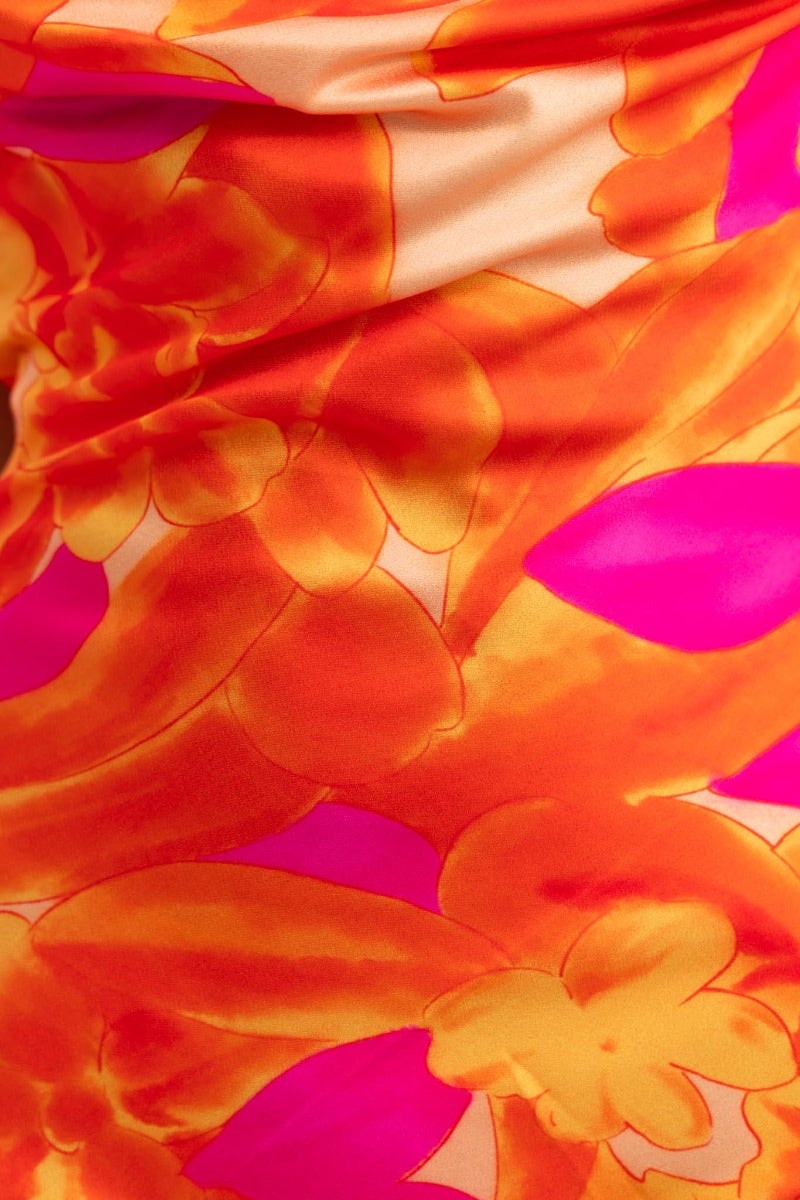 Close-up of vibrant multi-colour floral pattern on the Jiah Maxi Dress in orange and pink hues.