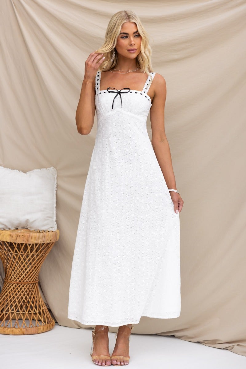 Cottage Dreams maxi dress with adjustable straps and ribbon detailing, modeled by a woman in a stylish setting.