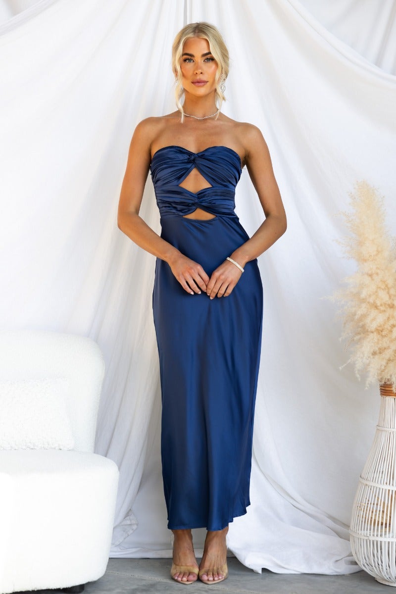 Model wearing a navy Zadora maxi dress featuring a strapless cut, cut-out detail, and zip closure at the back.