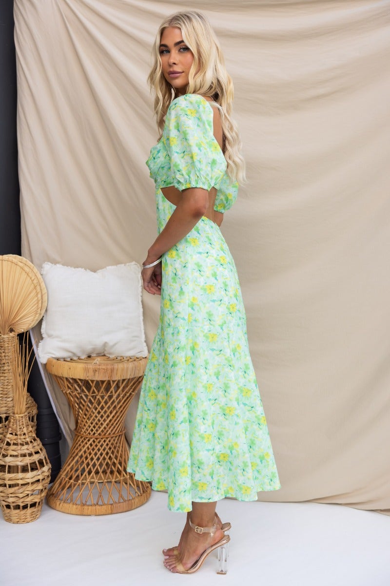 Zesty Midi Dress in floral print, featuring a cut-out waist, puff sleeves, and a flowy skirt, perfect for summer occasions.
