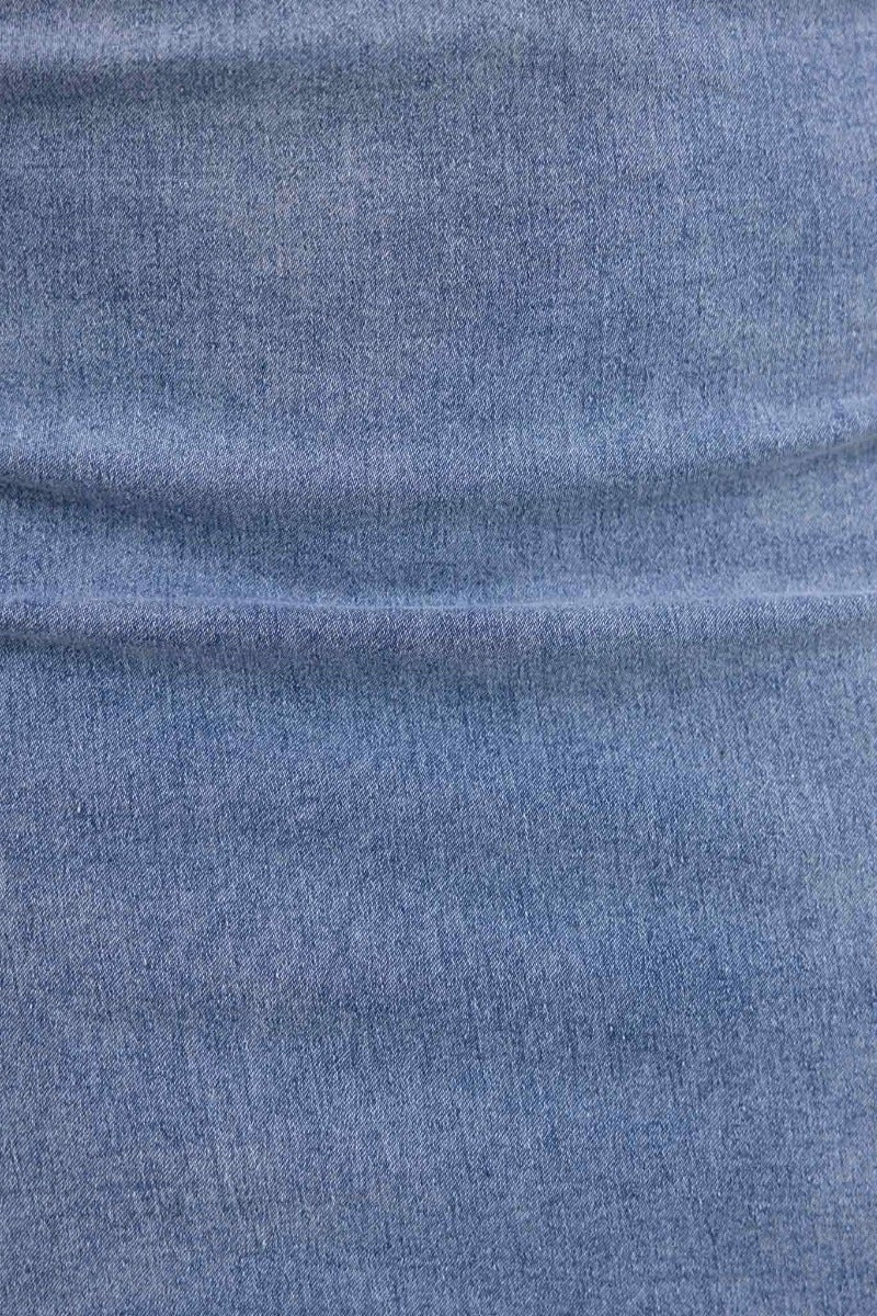 Close-up of blue denim fabric used in Zandon Denim Dress, showcasing its smooth texture and stretch material.