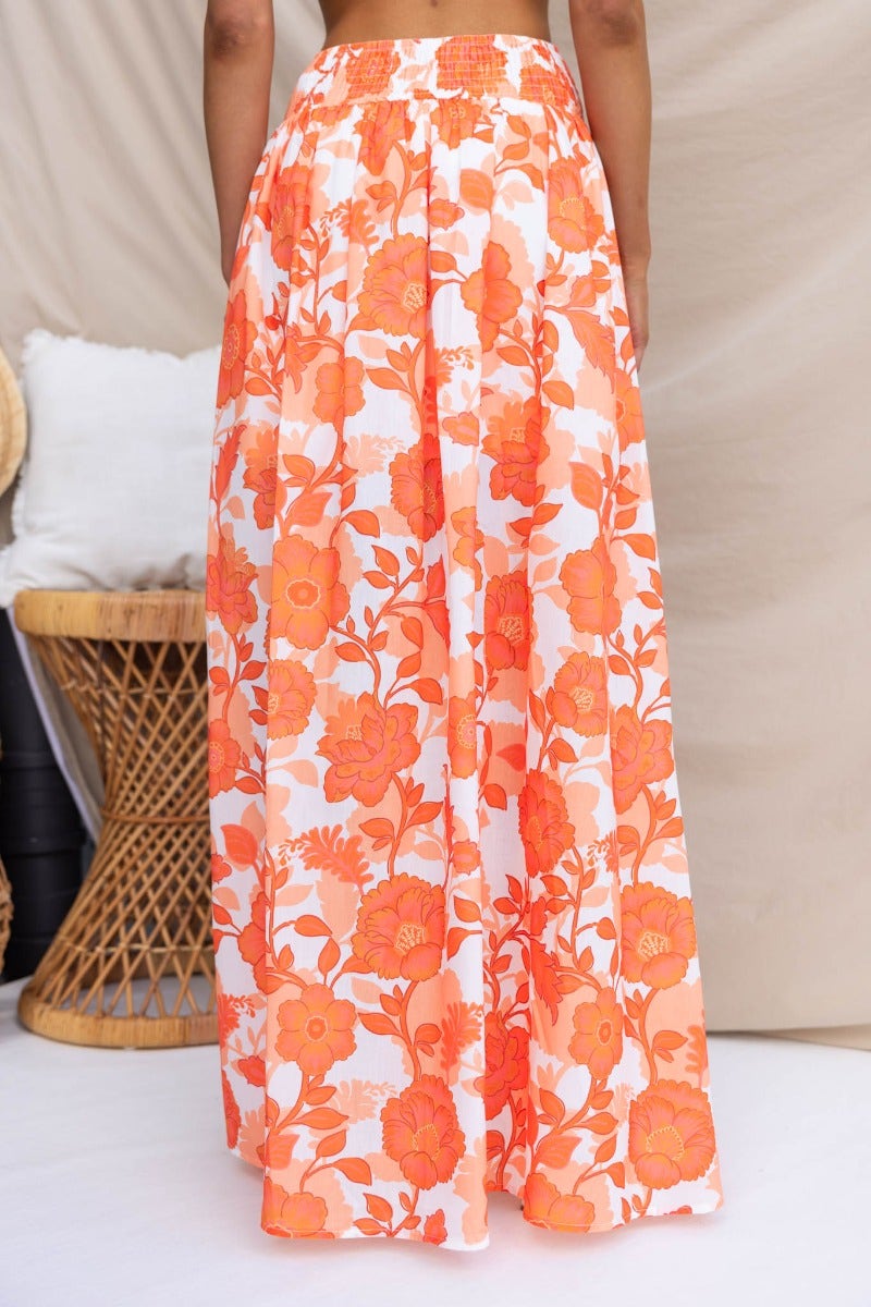 Floral print Idella maxi skirt featuring vibrant orange blooms, elastic waistband, and stylish front split.