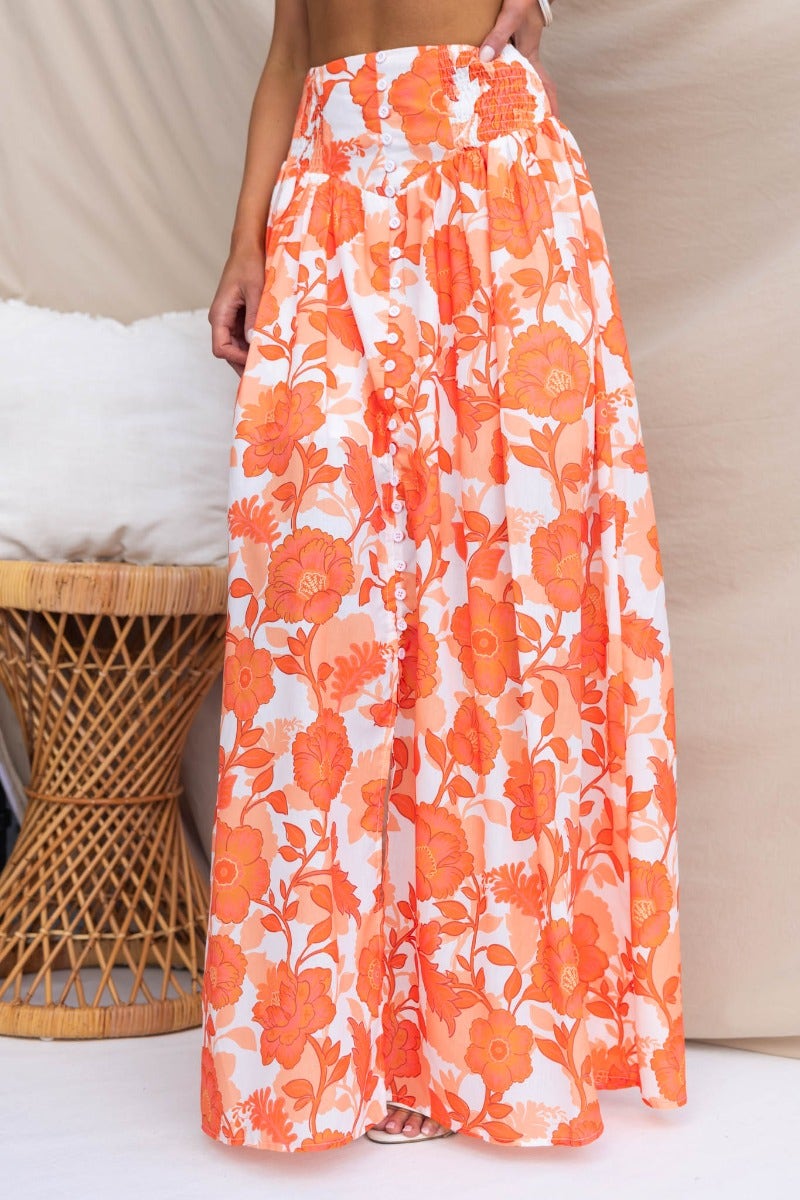 Floral print Idella Maxi Skirt in orange, featuring an elastic waistband and front split detail.