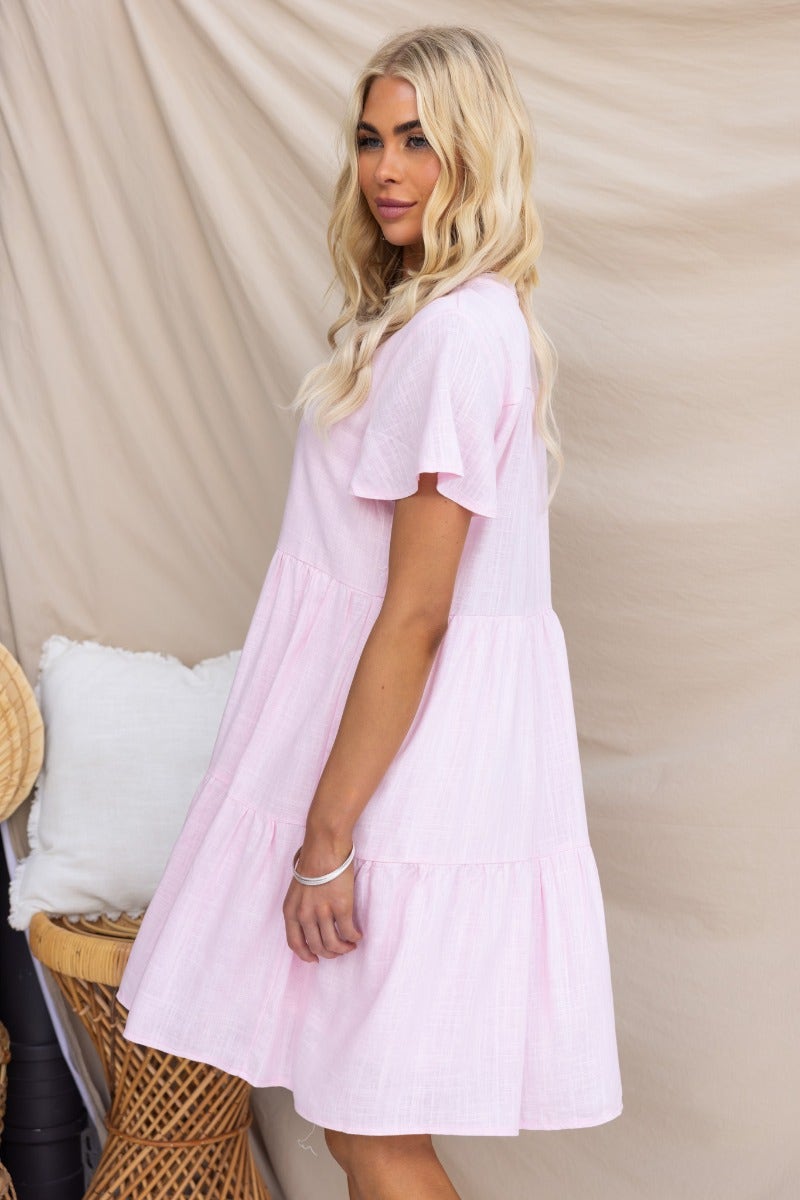 Model showcasing a pink linen blend dress with a relaxed fit and V-neckline, perfect for casual summer wear.