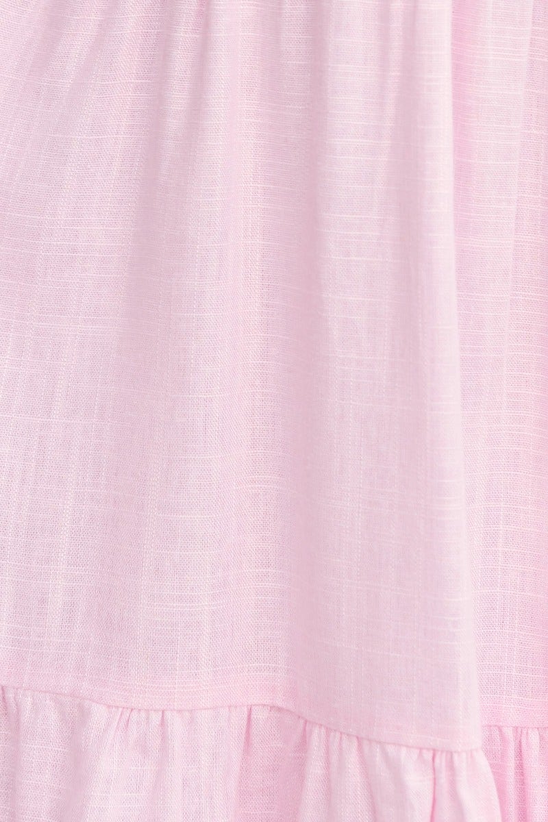Close-up of soft pink linen blend fabric with textured detail, perfect for a relaxed and stylish dress.