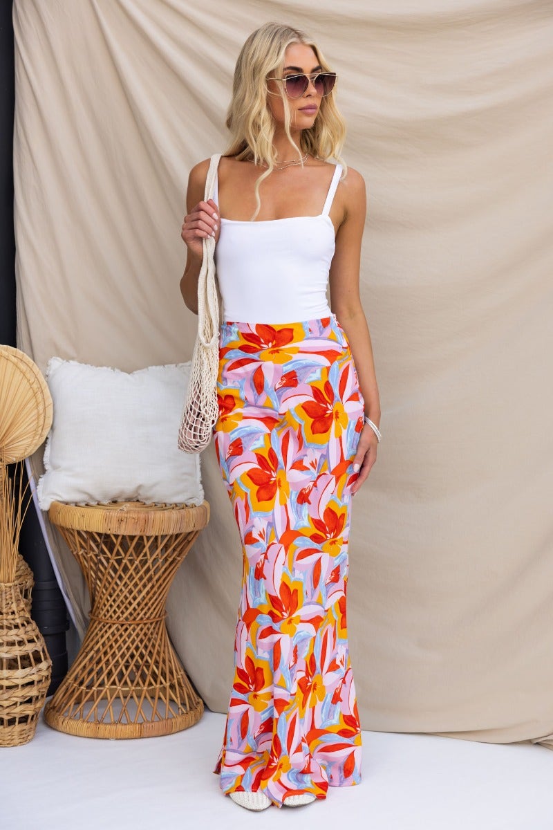 Model wearing Heartful Maxi Skirt, a floral print maxi with side zip, styled with a white top and accessories.