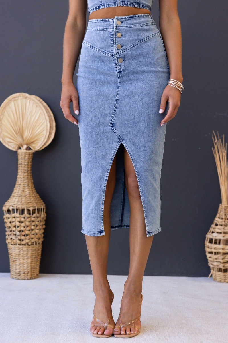 Genevieve Midi Skirt in denim with button-up front, high split, and stretch material. Model wears size 6/XS.