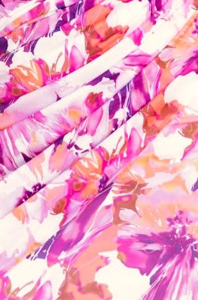 Close-up of vibrant floral print fabric in shades of pink and purple, showcasing draping detail for the Kassani Dress.