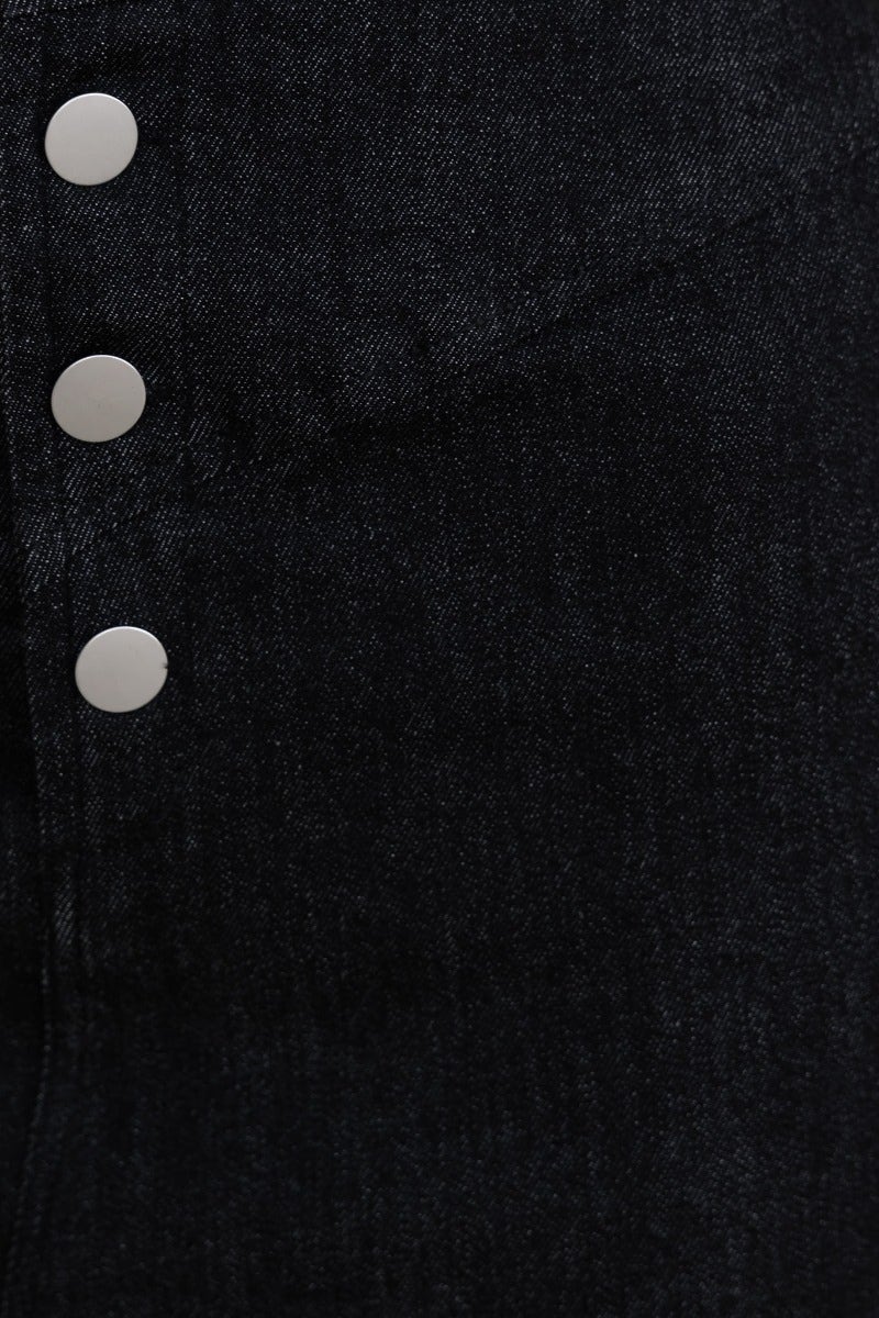 Close-up of Genevieve Midi Skirt buttons, featuring a black denim fabric with a high split and stretch material.