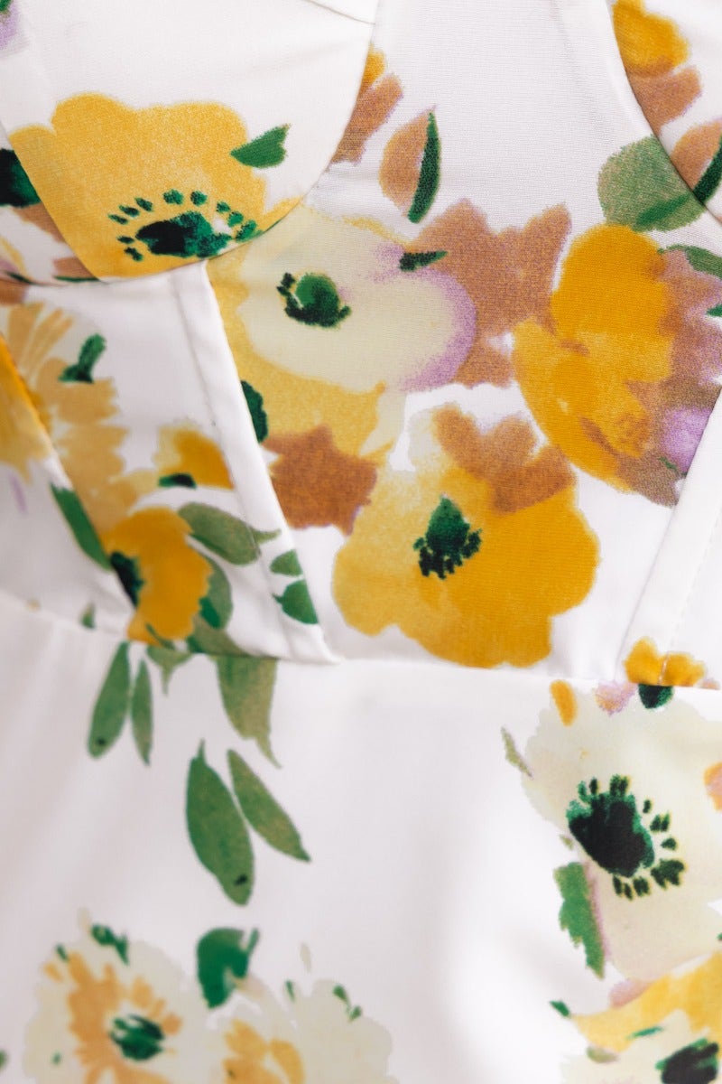 Close-up of Zephyr Midi Dress featuring floral print in yellow and green hues with padded bust detail.