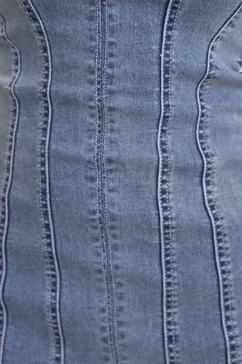 Close-up of Haze Denim Dress fabric, showcasing the raw hemline and textured denim material.