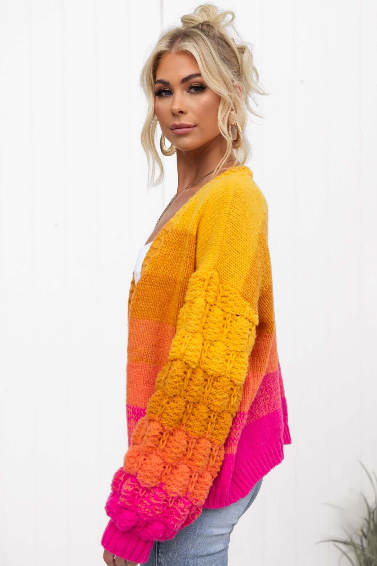 Xylia cardigan in vibrant yellow and pink, showcasing a stylish knit design, worn by a model.